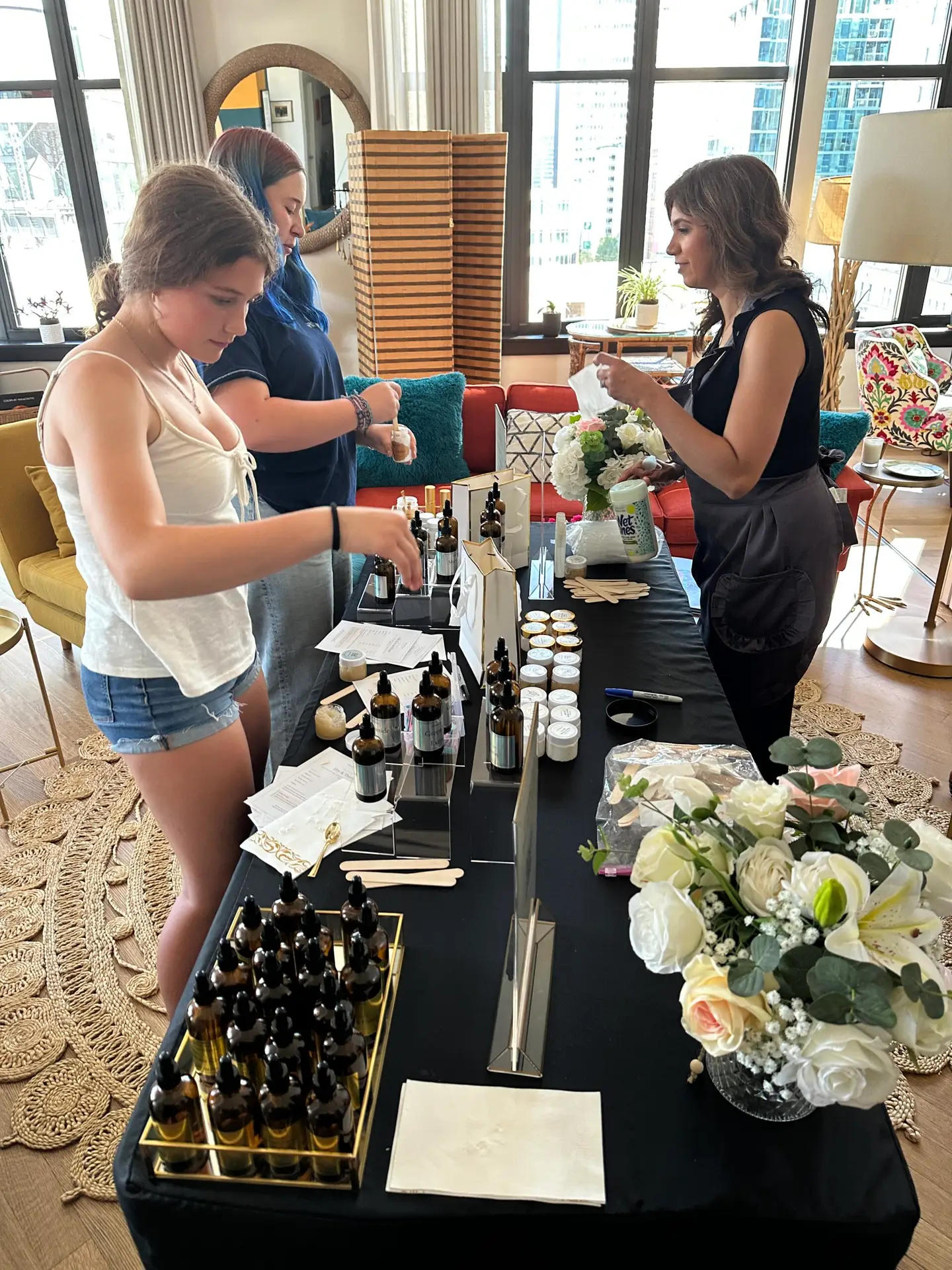 A styled skincare bar set up for a bridal shower, with risers, linens and florals